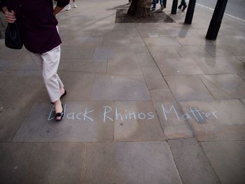 Low section of person with text on tiled floor