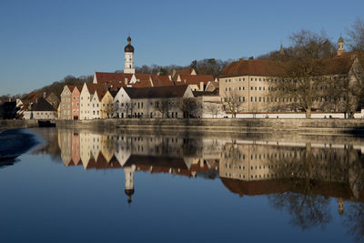 Reflection of building in lake against clear sky