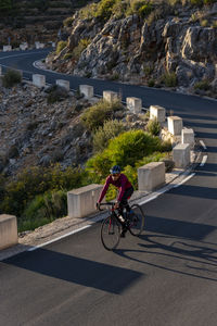 Man riding bicycle on road in city