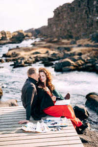 Woman sitting on rock at beach