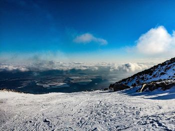 Scenic view of snow covered landscape against blue sky