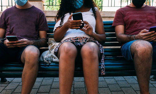 Low section of people sitting on mobile phone