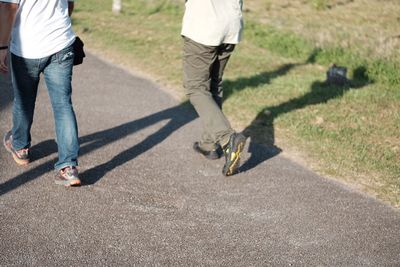 Low section of men standing on road