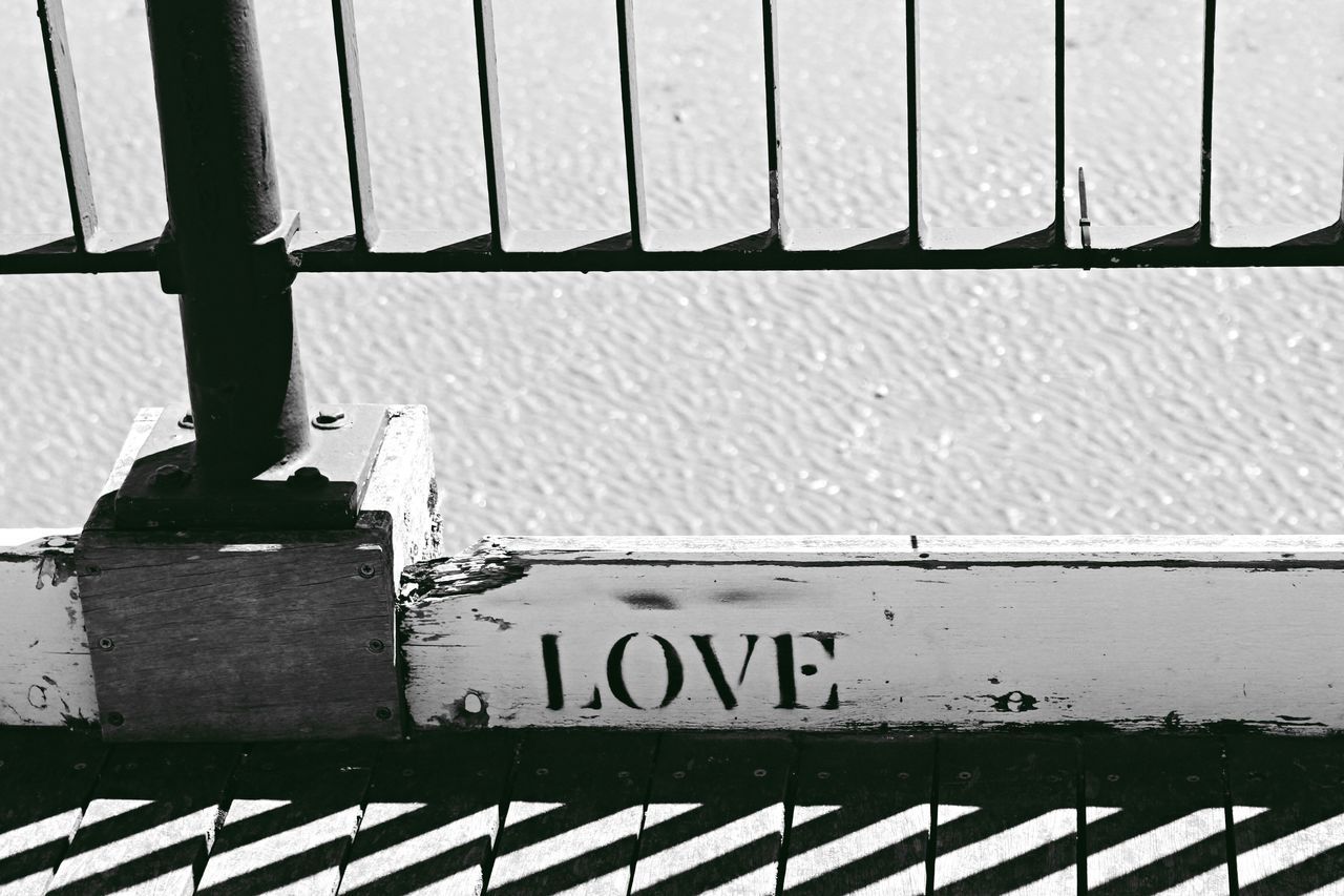 TEXT ON METAL FENCE AGAINST SIGN