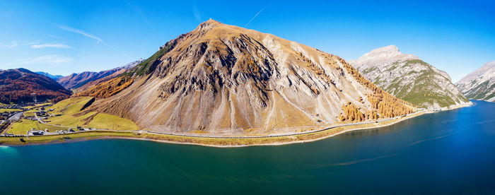 Panoramic view of lake and mountains against blue sky