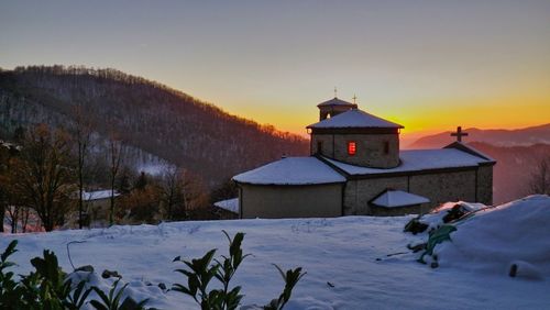 Built structure on snow covered building against sky