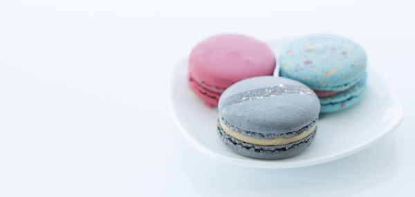 Close-up of candies in plate against white background