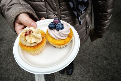 Close-up of person holding cupcakes