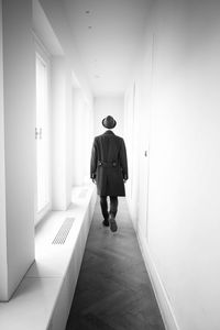 Rear view of man walking in corridor