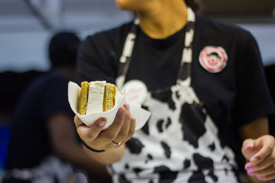 Midsection of chef holding ice cream sandwich