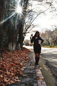 Full length of woman standing at park during autumn