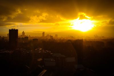 Silhouette cityscape against sky during sunset