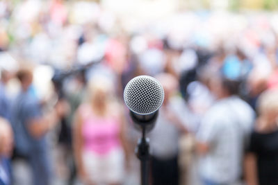 Close-up of microphone against crowd