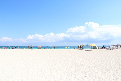 Panoramic view of people on beach against sky