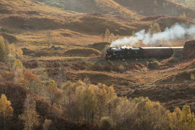 Steam train passing through scottish countryside 