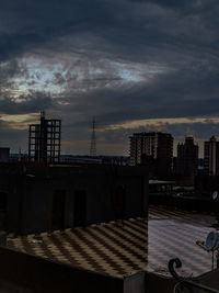 Buildings in city against sky at sunset