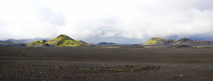 Scenic view of mountains against cloudy sky