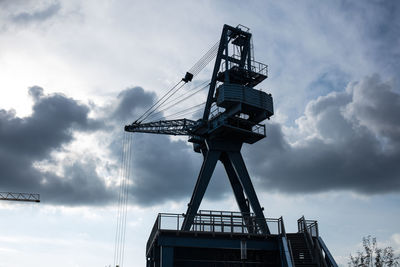 Low angle view of crane against sky