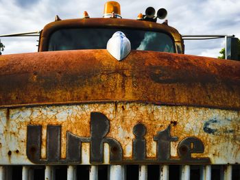 Rusty abandoned car against sky