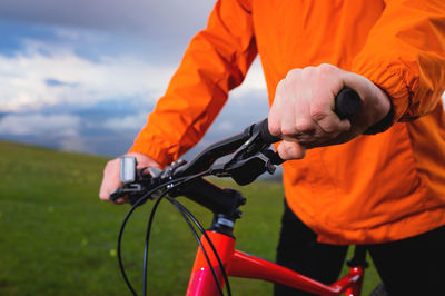 Midsection of man riding bicycle on field