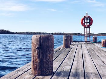 Wooden jetty on pier by sea against sky