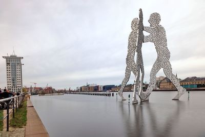 Bridge over river against buildings in city