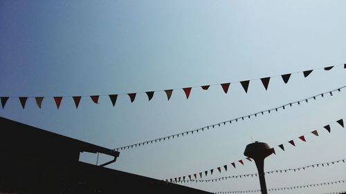 Low angle view of flags hanging against sky during sunset