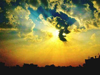 Silhouette of built structure against cloudy sky