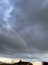 Low angle view of rainbow against cloudy sky