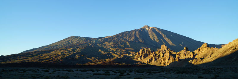 Scenic view of volcanic mountain against clear blue sky - el teide national parc, teneriffa