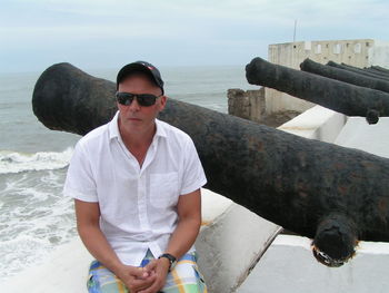 Portrait of man standing on beach against sky