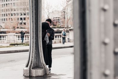 Couple standing by column