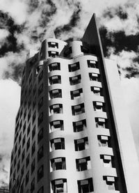 Low angle view of modern building against cloudy sky