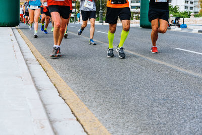 Low section of people running on road in city