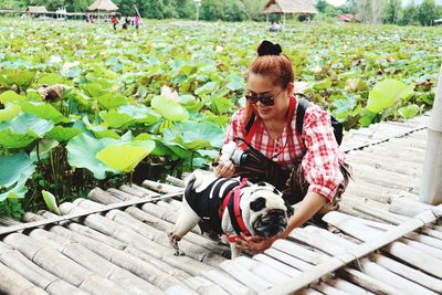 Woman with dog on boardwalk by agricultural field