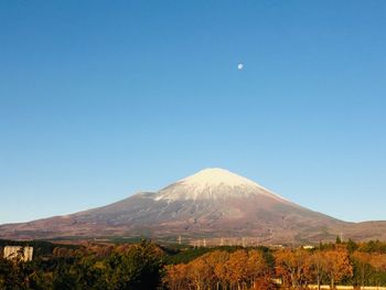 Scenic view of snowcapped mountain against blue sky