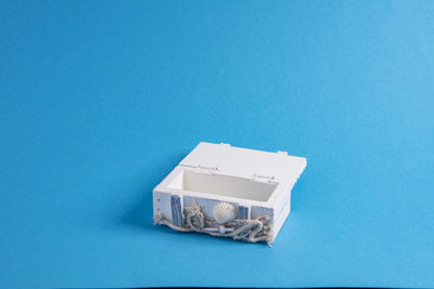 High angle view of white paper on table against blue background