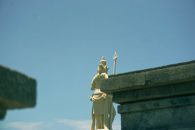 Low angle view of statue against clear blue sky