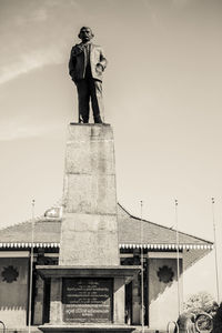 Woman statue in city against sky