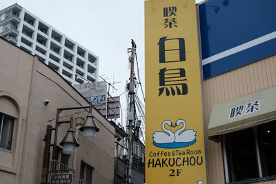 Low angle view of road sign against sky