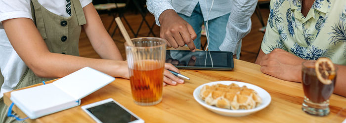 Young people looking at the tablet in a coffee shop