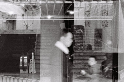 Digital composite image of people walking on glass window