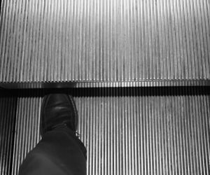Low section of man standing on escalator