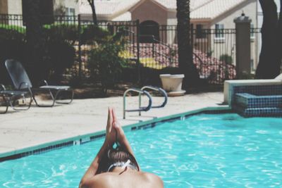 Low section of woman relaxing in swimming pool
