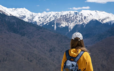 Rear view of woman looking at snowcapped mountain