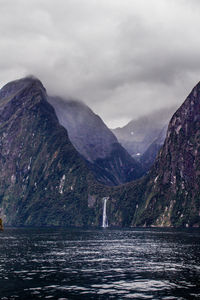 Scenic view of lake by mountains against sky