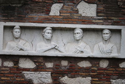 Close-up of statue against brick wall