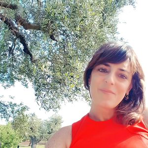 Portrait of young woman standing against trees