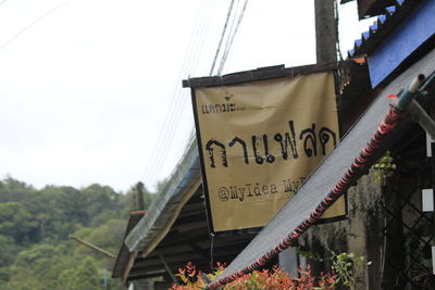 Low angle view of information sign against sky