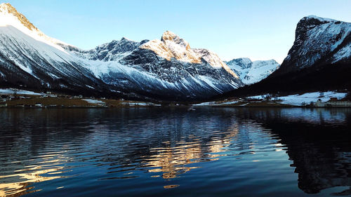Scenic view of lake and snowcapped mountains against sky